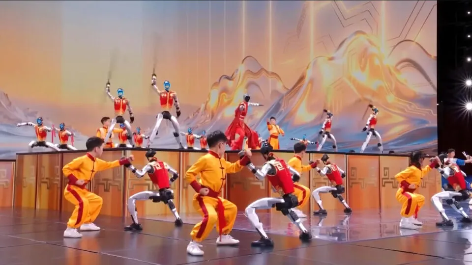 Jovens artistas marciais danam em perfeita sincronia com robs humanoides