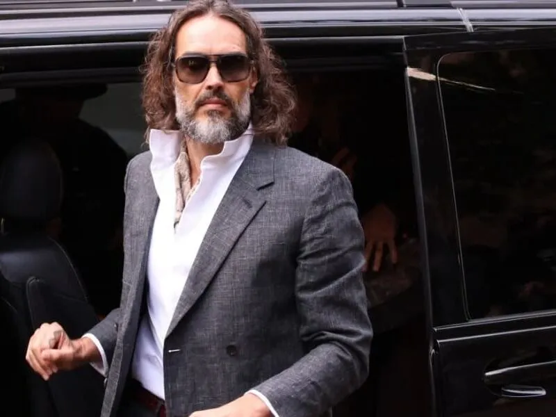 Ator Russell Brand comparece ao início de seu julgamento por estupro no Reino Unido